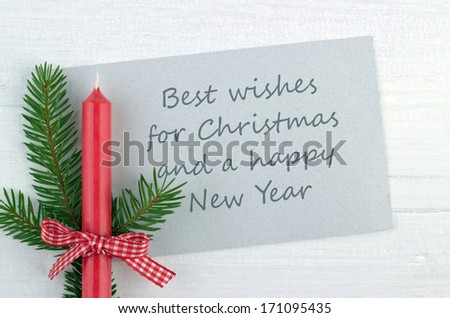 red candle, fire branch and christmas card/merry christmas and a happy New Year/english