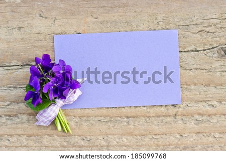 Bunch of violets and card on a wooden board/violets/bouquet