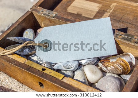 Wooden box with stones, shells and map in the sand / Treasure Chest / beach