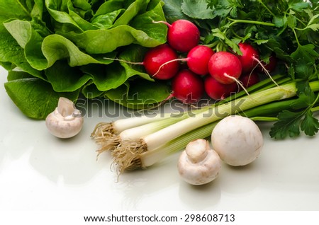 Lettuce, onion, parsley, red radish, mushrooms on table