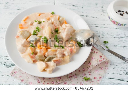 Chicken and vegetables with milk sauce on a plate