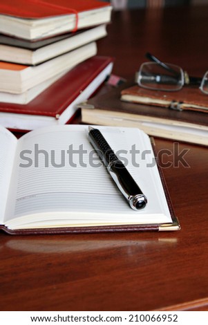 Working desk Open notebook with pen and glasses