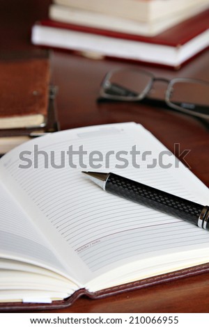 Working desk Open notebook with pen and glasses