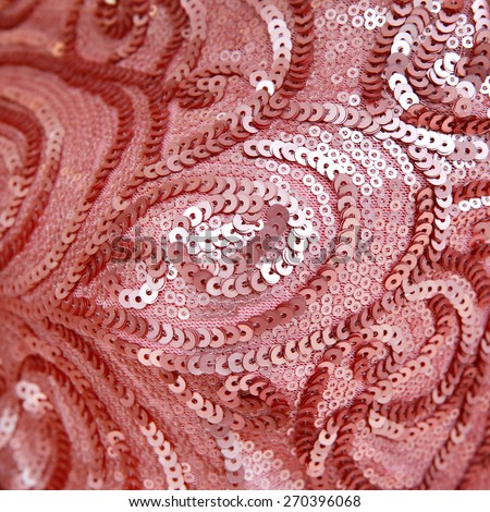 Close up of a pale pink dress covered with shiny pink sequins