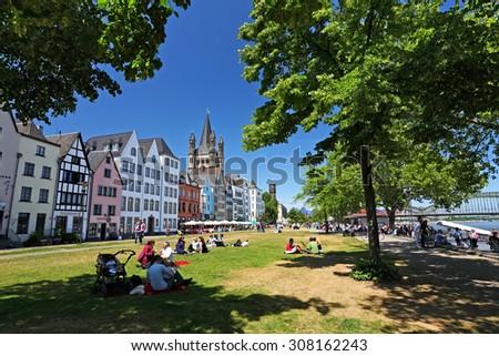 COLOGNE, Germany - May 29: Buildings along an embankment and the High Cathedral of St. Martin near Hohenzollern Bridge on May 29,2011 in Cologne, Germany. Leisure and pleasure of travelers on vacation