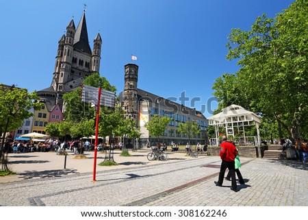 COLOGNE, Germany - May 29: Buildings along an embankment and the High Cathedral of St. Martin near Hohenzollern Bridge on May 29,2011 in Cologne, Germany. Leisure and pleasure of travelers on vacation