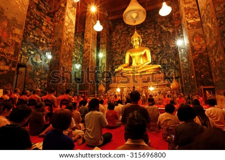 BANGKOK, THAILAND - MAR 31: Unidentified buddhist monks and People Praying at Wat Suthat Thepwararam on March 31, 2012 in Bangkok, Thailand. It is the respect and esteem of the people of Bangkok