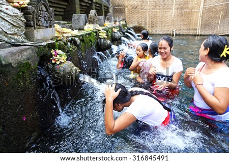 BALI, INDONESIA - JUN 19 : Unidentified Balinese people come to the sacred springs water temple of Tirta Empul on June 19, 2015 in Bali, Indonesia. It is a to pray and cleanse of Balinese