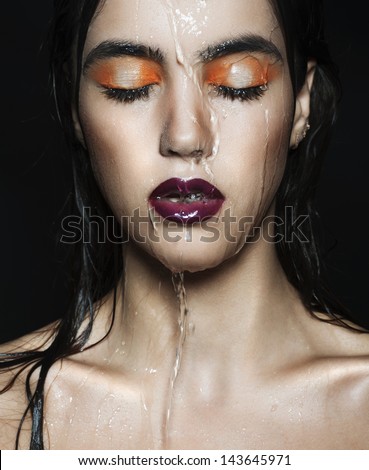 Beautiful young woman in water with wet hair and face. Beauty and fashion.