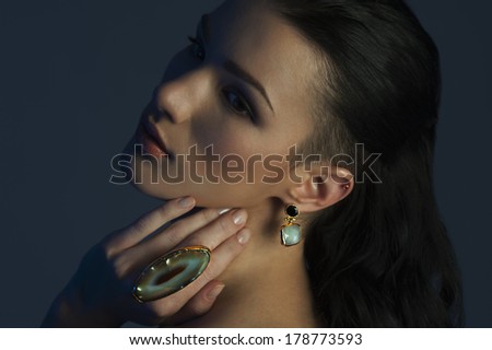 portrait of the beautiful fashion woman with black and gold makeup. Gold jewerly. expensive and luxurious