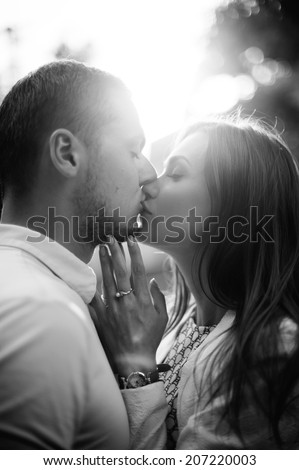 Outdoor lifestyle portrait of young couple in love standing in old town on the street behind sunset