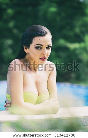 Young pretty fashion sport woman posing outdoor in summer on tropic island in hot weather in bikini in the park