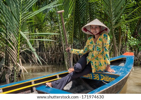 VINH LONG, VIETNAM - MARCH 6: Vietnamese woman posing in a traditional boat in the Mekong delta on March 6, 2009 near Vinh Long. The Mekong river is a major route for transportation in Southeast Asia.