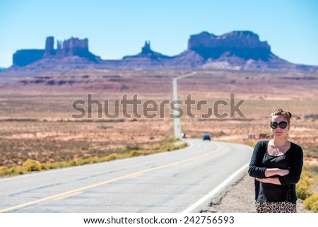 Female tourist poses at the classic route to Monument Valley