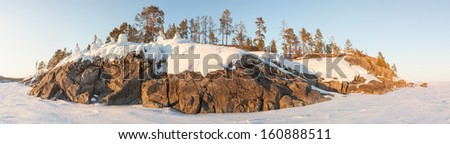 Winter, stony snow-covered island of Ladoga lake. A winter landscape. A panorama, winter landscape