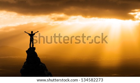 man on the top of a rock  meeting sun  - success concept