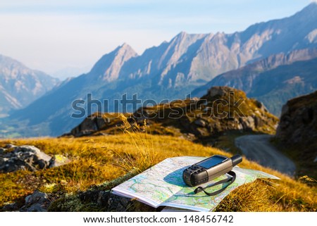 GPS navigator and map on Alps mountain background