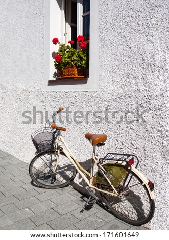 An old fashioned delivery bicycle leaning against a wall