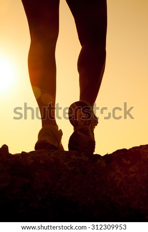 silhouette of fitness girl legs running at sunset
