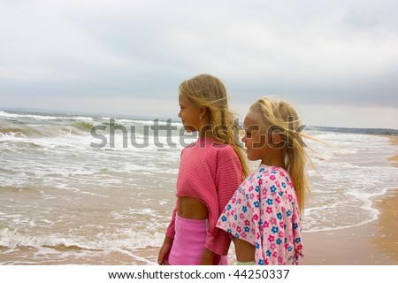 two little girl looking ahead on the beach