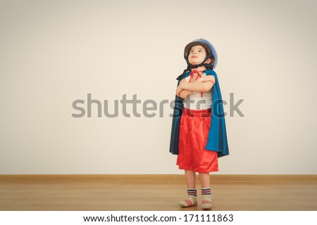 Funny little power super hero child (boy) in a blue raincoat.  Superhero concept