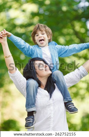 Cheerful smiling boy with mother playing on spring park. Mother`s day concept