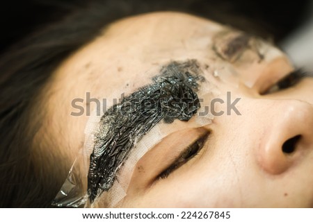 Makeup eyebrow tattooing, pretty asian woman face closeup