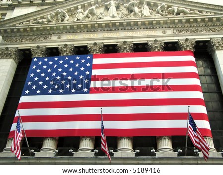View of New York Stock Exchange facade draped with American flag. (New York City)