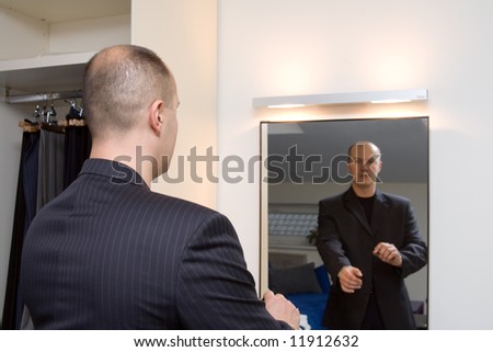 Businessman spend his time in front of the mirror.