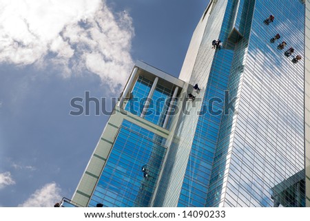 Skyscraper and working  industrial mountaineers on it.