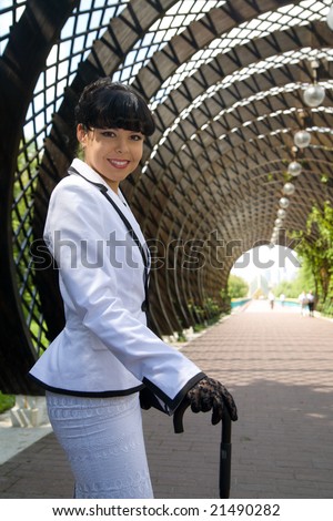 Young woman from high society walking at sunny day in city.