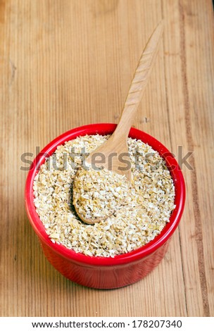 oat bran in ramekin on wooden surface