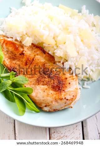 Grilled chicken breast with pineapple rice on plate