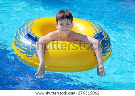 Boy in the swimming pool on inner tube
