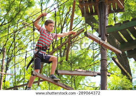 Boy is climbing in rope attraction park