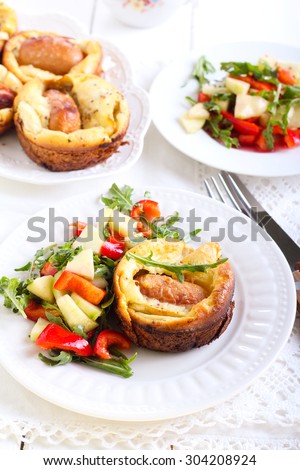 Sausage and apple Toad  in  the hole and salad on plate