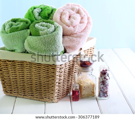Spa setting with towels, sea salt and aroma oil over light background
