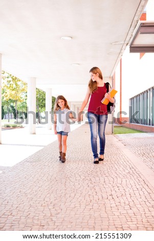 Beautiful mother and daughter walking to school