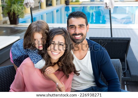 Beautiful latin family relaxing close to the pool