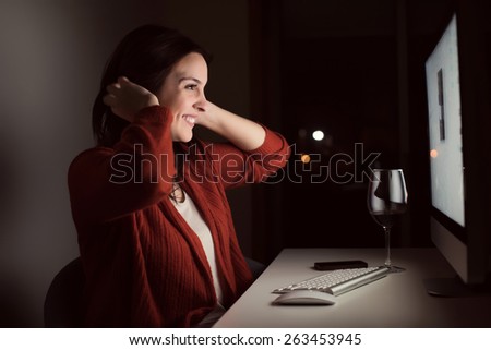 Woman in video call with a glass of wine on desk