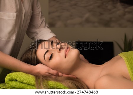 Young woman having a facial massage at the spa