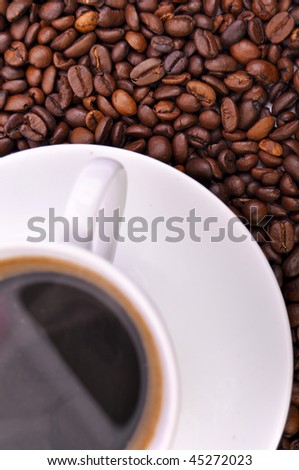 Cup of coffee on beans. Focus on beans