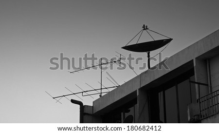 Black and white: Satellite dish and old fishbone tv antenna