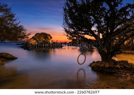 Small island surrounding by sea water with reflection at dusk with twilight sky, Ko Man Klang, Rayong, Thailand. Holiday maker or summer vacation in tropical country, Siam. Stock fotó © 