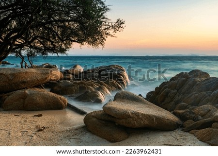 Seascape of moving wave through beautiful natural stone arch at sunrise in Ko Man Klang, Rayong, Thailand. Famous travel destination and summer holiday vacation in tropical country, Siam. Stock fotó © 