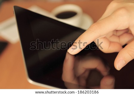 Hand toching tablet PC on business background