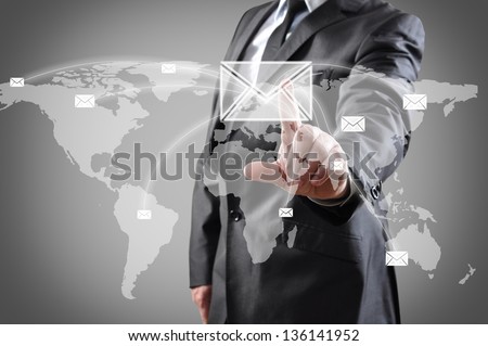 businessman pushing mail on world map on a touch screen interface.