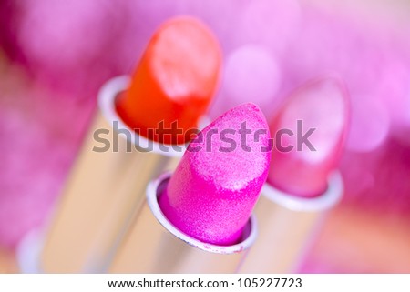 lipsticks colors with petals and glitters in the background