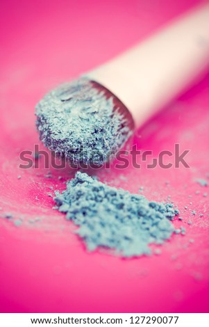 close-up shot of make-up brush with blue eyeshadow powder