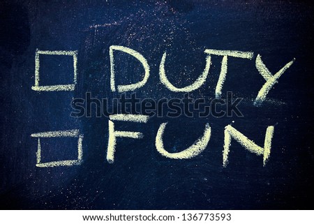 chalk writings on blackboard, choice between duty or fun